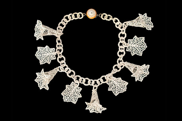 Horizontal front view of 1930s vintage cream lace look floral and leaf celluloid plastic statement necklace.
