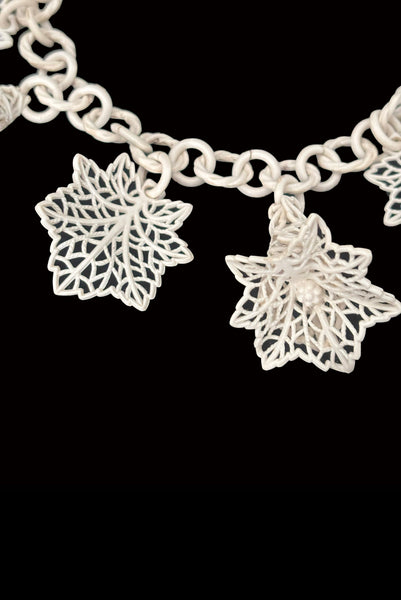 Detail view of 1930s vintage cream lace look floral and leaf celluloid plastic statement necklace. Showing a close up of the 3-dimensional flowers and leaves.
