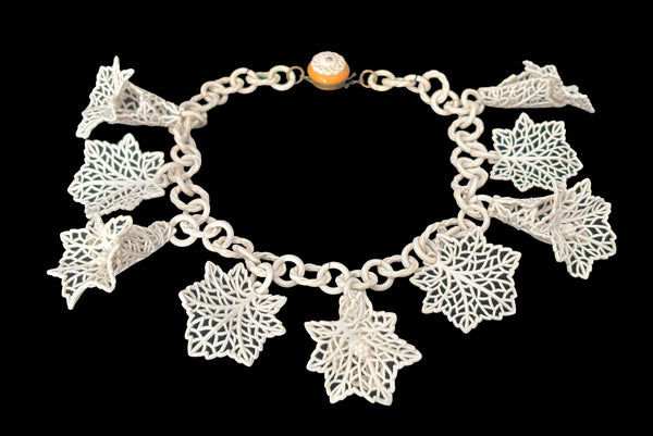 Horizontal perspective view of 1930s vintage cream lace look floral and leaf celluloid plastic statement necklace.