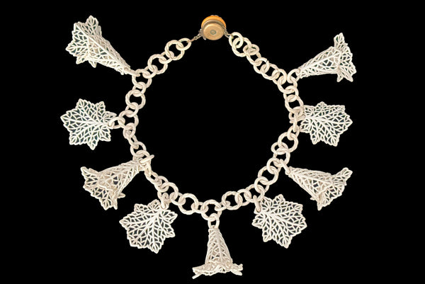 Horizontal back view of 1930s vintage cream lace look floral and leaf celluloid plastic statement necklace.