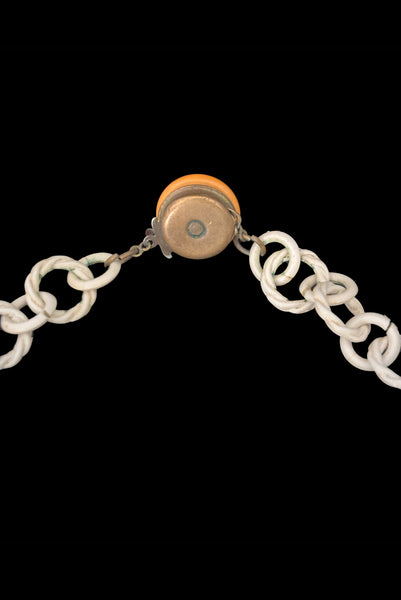 Detail view of 1930s vintage cream lace look floral and leaf celluloid plastic statement necklace. Showing a close up of the back of the Bakelite, celluloid, and brass clasp.