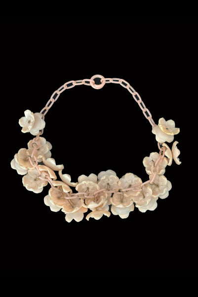 Vertical back view of 1930s vintage blush pink three-dimensional floral celluloid plastic statement necklace.