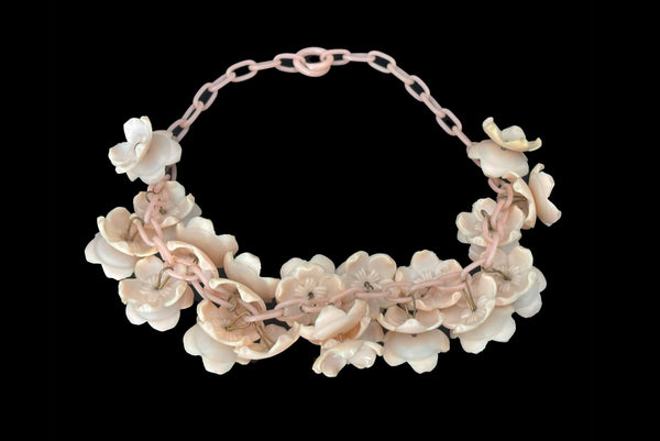 Horizontal back view of 1930s vintage blush pink three-dimensional floral celluloid plastic statement necklace.