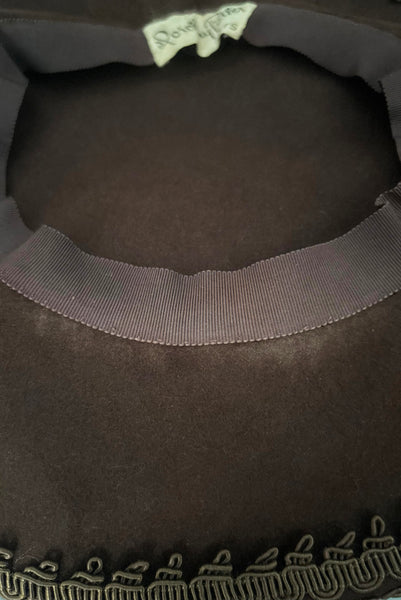 Detail view of 1940s vintage chocolate brown felt wide brim saucer hat trimmed in matching braid, by Dorothy Potter. Showing a lighter spot in the front from the hat touching a forehead.