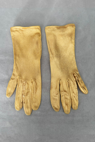 Vertical front view of 1950s vintage wrist length metallic gold nylon gloves. Approximately size 5.