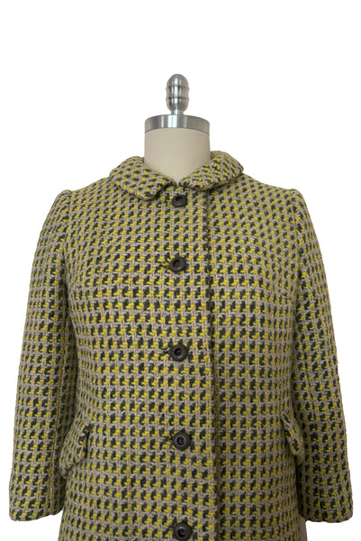 Detail view of 1960s vintage citron yellow, gray, and white bracelet sleeve, knee length wool coat, by Paul Blumenstein, size small to medium. Showing the collar and gray plastic buttons.