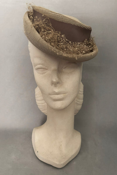 Vertical front view of 1940s vintage taupe straw riding style tilt topper hat with matching petersham ribbon and veiling trim, by Marche.