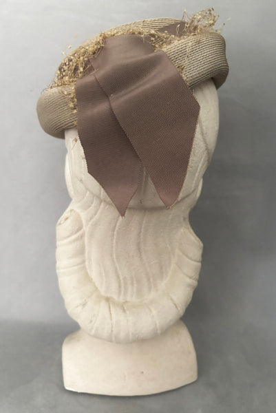 Vertical back view of 1940s vintage taupe straw riding style tilt topper hat with matching petersham ribbon and veiling trim, by Marche.