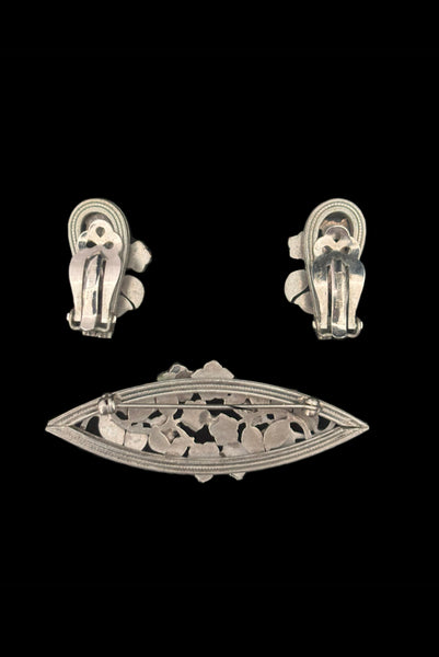 Vertical back view of 1950s vintage Whiting and Davis pewter floral brooch and clip-on earrings jewelry set.