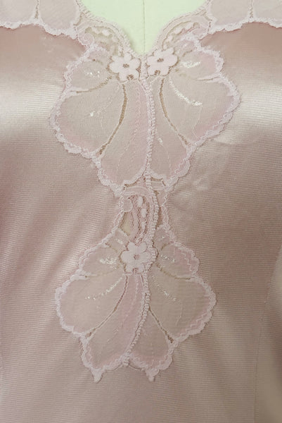 Detail view of 1970s vintage blush pink nylon tricot floral lace trimmed nightgown by Maidenform, size extra small to small. Showing a close-up of the floral lace trim.