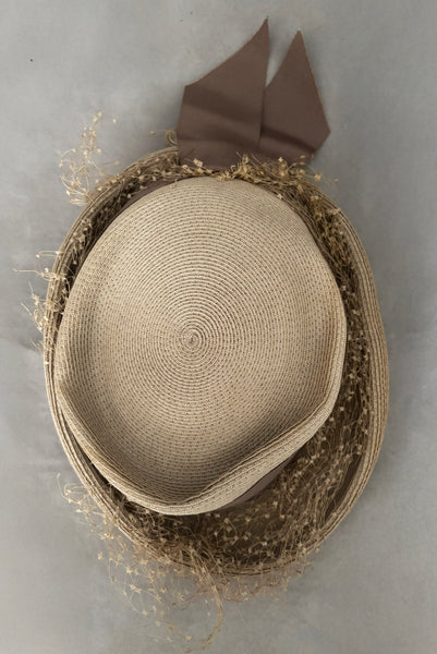 Vertical top view of 1940s vintage taupe straw riding style tilt topper hat with matching petersham ribbon and veiling trim, by Marche.