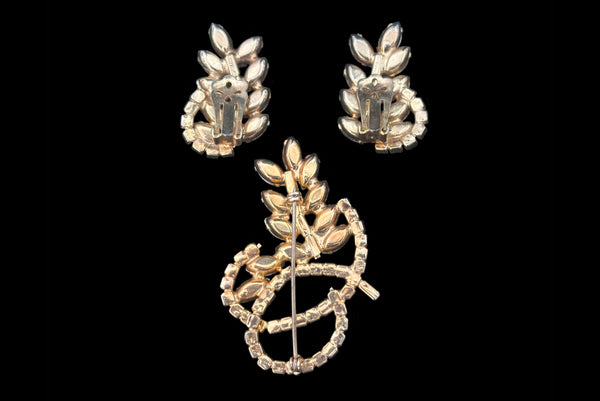 Horizontal back view of 1950s vintage iridescent and amethyst purple rhinestone leaf brooch and clip-on earring set.