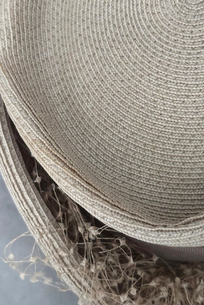 Detail view of 1940s vintage taupe straw riding style tilt topper hat with matching petersham ribbon and veiling trim, by Marche. Showing a light mark on the straw.