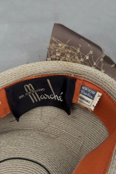 Detail view of 1940s vintage taupe straw riding style tilt topper hat with matching petersham ribbon and veiling trim, by Marche. Showing the Marche and New York Creation labels.