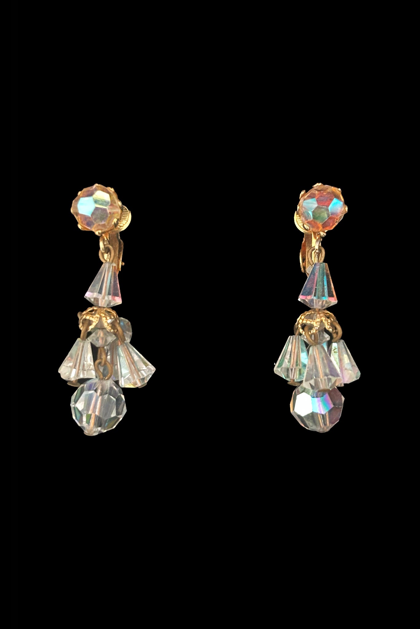 Vertical front view of 1960s vintage iridescent crystal bead and gold tone chandelier drop earrings.