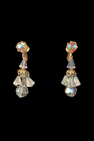 Vertical front view of 1960s vintage iridescent crystal bead and gold tone chandelier drop earrings.