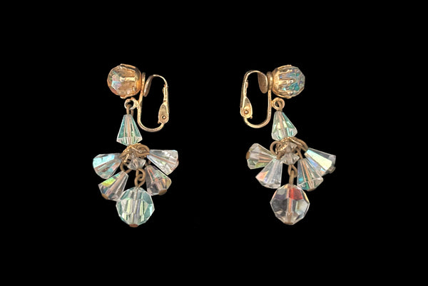 Horizontal side view of 1960s vintage iridescent crystal bead and gold tone chandelier drop earrings.