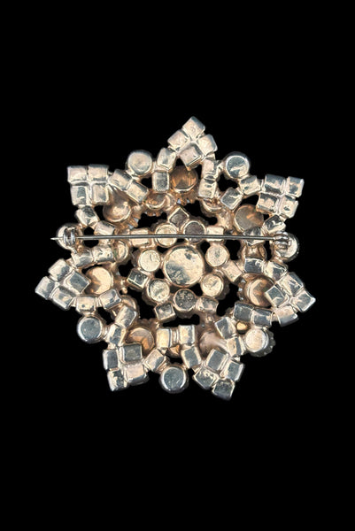 Vertical back view of 1950s vintage large round iridescent pink rhinestone snowflake statement brooch.