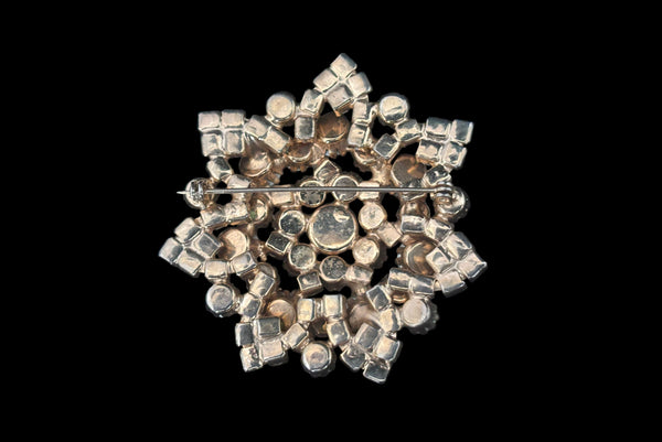 Horizontal back view of 1950s vintage large round iridescent pink rhinestone snowflake statement brooch.