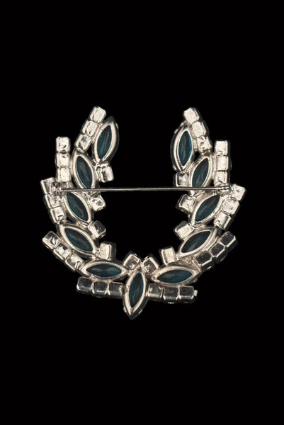 Vertical back view 1950s vintage iridescent blue round  and aqua marquise rhinestone and silver tone metal horseshoe brooch.