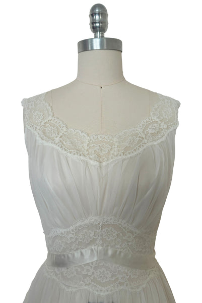 Bodice front view of 1940s vintage white nylon bridal lingerie ballerina nightgown by Vanity Fair, size small to medium. Showing the lace trimmed scoop neckline and lace and ribbon midriff.