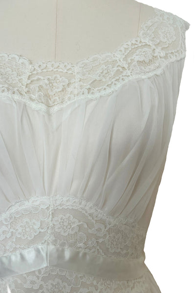 Detail view of 1940s vintage white nylon bridal lingerie ballerina nightgown by Vanity Fair, size small to medium. Showing the lace trimmed scoop neckline, gathered bodice, and lace and ribbon midriff.