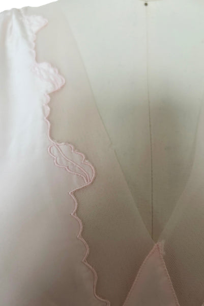 Detail view of 1930s vintage blush pink rayon and mesh lingerie applique bias cut nightgown by Seamprufe, size small to medium. Showing the scalloped leaf applique mesh deep V neckline.