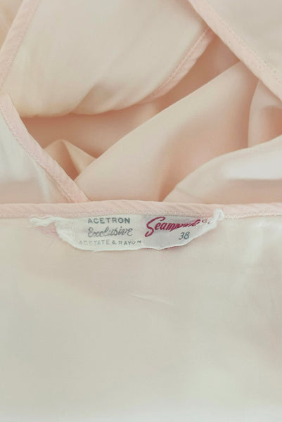 Interior detail view of 1930s vintage blush pink rayon and mesh lingerie applique bias cut nightgown by Seamprufe, size small to medium. Showing the Seamprufe, size 38 label.