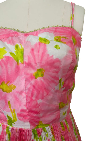 Detail view of 1950s vintage pink, white, and chartreuse green watercolor floral print sweetheart neckline pleated skirt playsuit/mini dress by Gabar, size small to medium. Showing the adjustable straps and green lace trimmed sweetheart neckline.