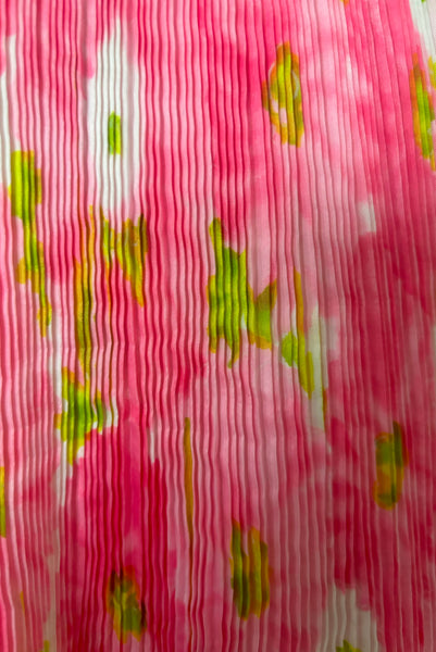 Detail view of 1950s vintage pink, white, and chartreuse green watercolor floral print sweetheart neckline pleated skirt playsuit/mini dress by Gabar, size small to medium. Showing a close-up of the micro pleated skirt.