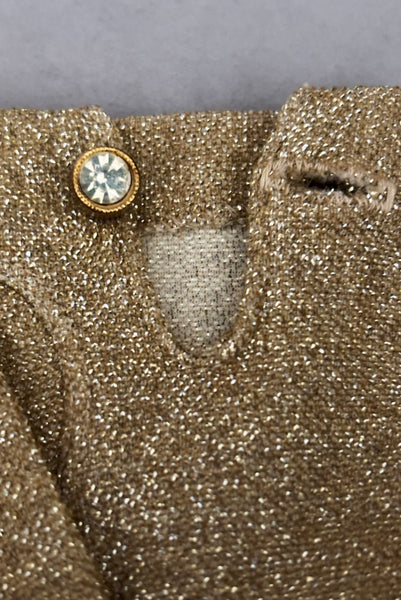 Detail view of 1950s vintage wrist length stretchy metallic gold nylon mylar gloves with clear rhinestone buttons. Showing a close-up of the wrist with rhinestone button and button hole.