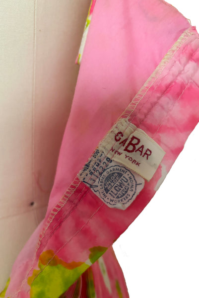 Interior detail view of 1950s vintage pink, white, and chartreuse green watercolor floral print sweetheart neckline pleated skirt playsuit/mini dress by Gabar, size small to medium. Showing the GaBar and Union labels.