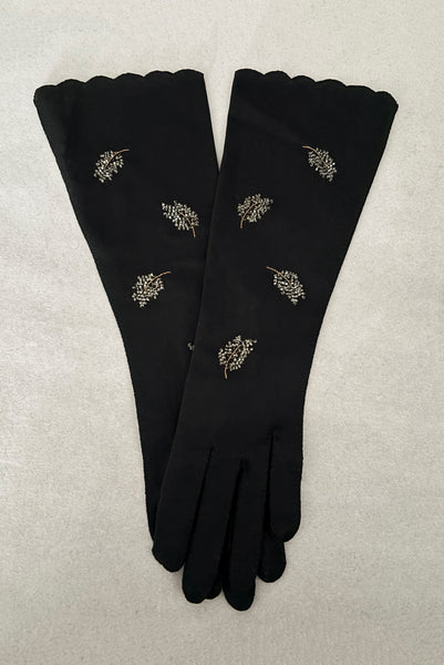 Vertical pair view of 1950s vintage mid length black Reindoe Nylon scalloped cuff gloves with gold embroidery and silver beaded leaves by Van Raalte, size 7.