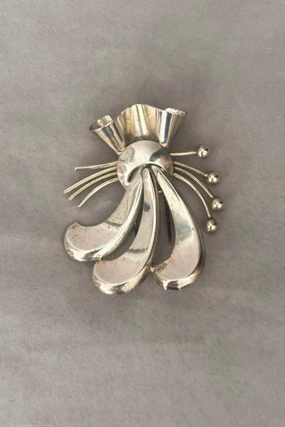 Vertical front view of 1930s vintage 925 sterling silver rhodium plated Modernist botanical fur clip by Napier.