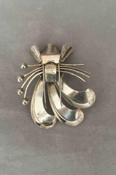 Vertical back view of 1930s vintage 925 sterling silver rhodium plated Modernist botanical fur clip by Napier.