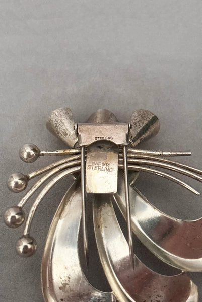 Detail view of 1930s vintage 925 sterling silver rhodium plated Modernist botanical fur clip by Napier. Showing the Napier and Sterling stamps.