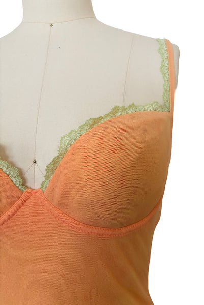 Detail view of 2000s y2k vintage, as is, new with tags creamsicle orange mesh and green lace underwire bustier with laced back by Cosabella, size extra small to small. Showing the cups with underwires trimmed in green lace.