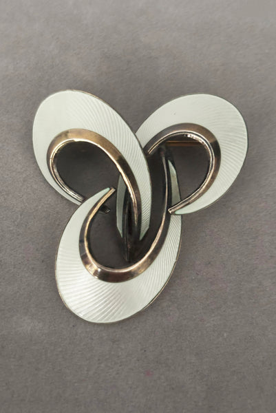Vertical front view of 1950s vintage Hans Myhre 925 sterling silver and white guilloche enamel brooch. Made in Norway.