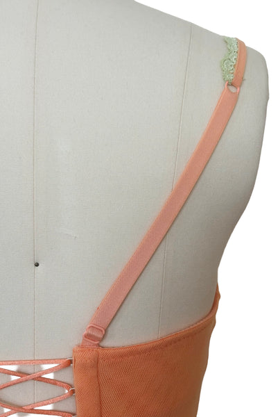 Detail view of 2000s y2k vintage, as is, new with tags creamsicle orange mesh and green lace underwire bustier with laced back by Cosabella, size extra small to small. Showing the stretched out elastic straps.