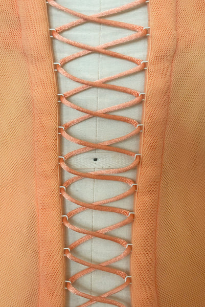 Detail view of 2000s y2k vintage, as is, new with tags creamsicle orange mesh and green lace underwire bustier with laced back by Cosabella, size extra small to small. Showing the metal eyes with satin cording on the laced up back.
