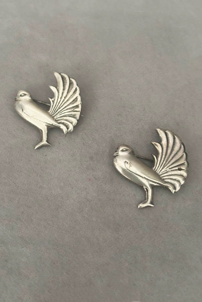 Vertical front view of 1930s vintage Mexican sterling silver pair of bird brooches.