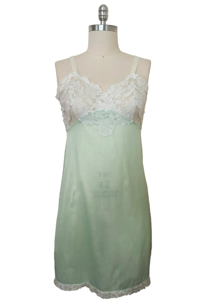 Front view of 1960s vintage pale mint green and white lace mini full slip by Philmade, medium to large.