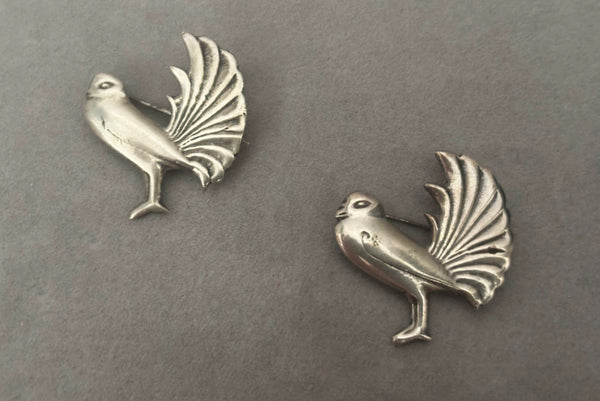Horizontal front view of 1930s vintage Mexican sterling silver pair of bird brooches.