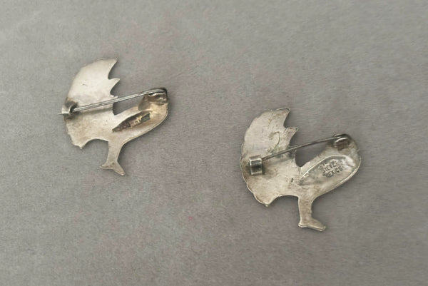 Horizontal back view of 1930s vintage Mexican sterling silver pair of bird brooches.