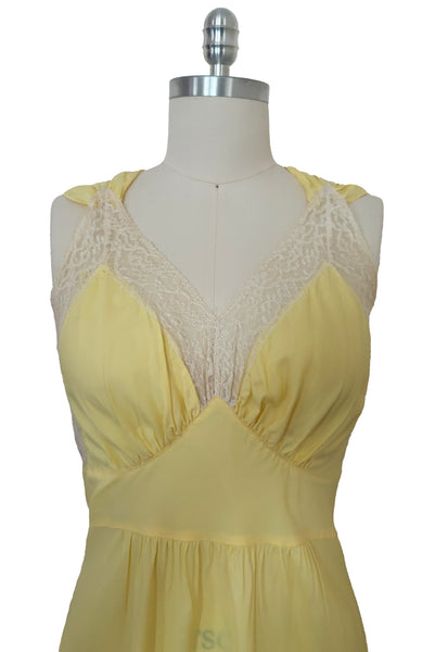 Bodice front view of vintage 1940s yellow bias cut rayon and cream lace sweetheart neckline nightgown, medium to large. Showing the ivory lace trimmed neckline, gathered bust, and pointed midriff band.