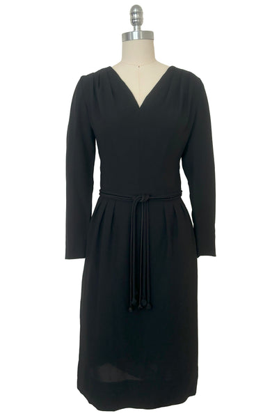 Front view of 1950s vintage long sleeve, V-neck black crepe wiggle dress with triple stand self tie belt, by R&K Originals, small to medium.