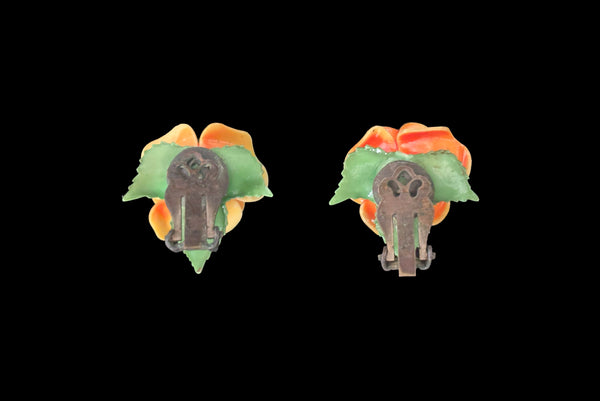 Horizontal back view of 1950s vintage orange and green plastic rose clip-on floral earrings.