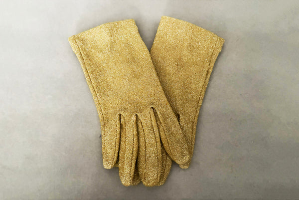Horizontal pair view of 1950s vintage wrist length stretchy metallic gold nylon mylar gloves with clear rhinestone buttons.