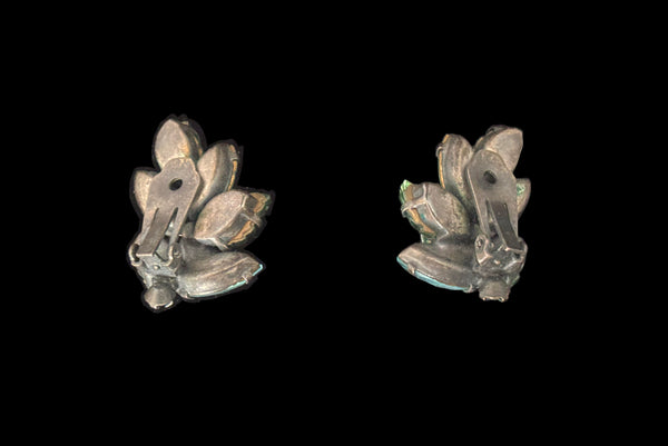 Horizontal back view of 1950s vintage iridescent teal blue green pressed glass and marquise rhinestone leaf clip-on earrings.