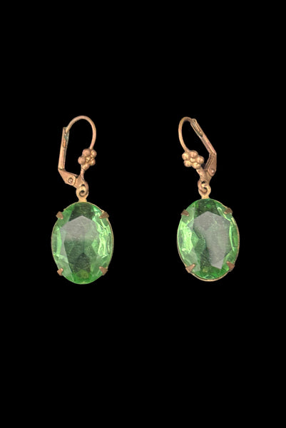 Vertical flat view of 2010s vintage faceted glass oval peridot green rhinestone and brass lever back drop earrings made from vintage components.